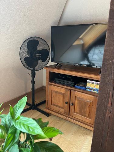 a fan in a living room with a television at Home sweet home in La Bresse