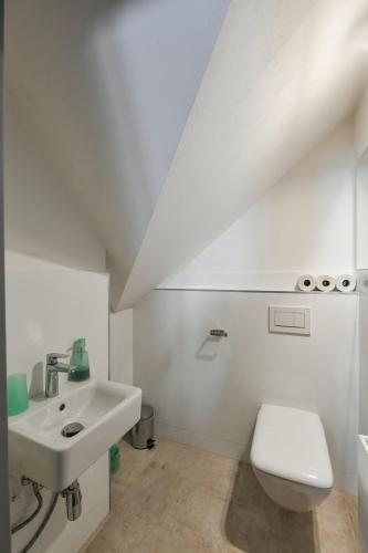 a white bathroom with a sink and a toilet at Apartmán v srdci Krkonoš in Horní Maršov