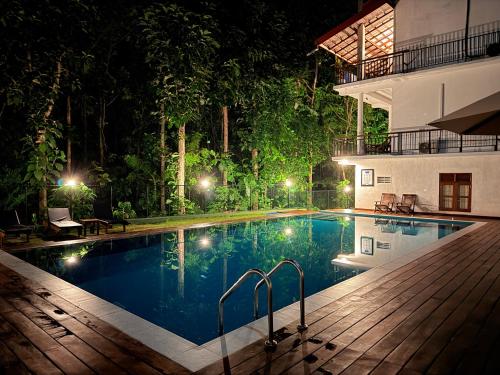 a swimming pool in a resort at night at Nature House in Udawalawe