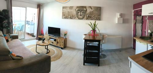a living room with a couch and a tv at La Perle Marine, Cosy et rénové, 200 m de la plage, 1 chambre, parking et Wifi in Sète