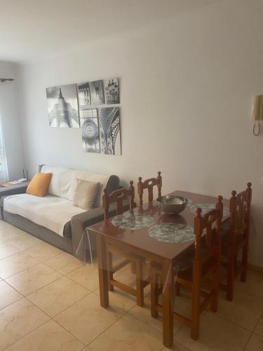 a living room with a table and a couch at Paris Lovely in Gran Tarajal