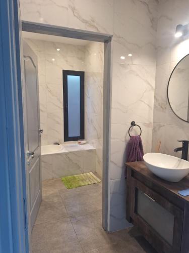 a bathroom with a sink and a tub and a mirror at Muana Escobar in Belén de Escobar