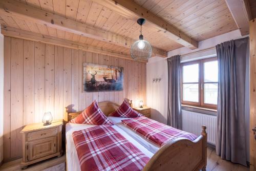 a bedroom with a bed with a plaid blanket at Mühlberger Hof in Petting