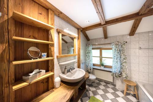 a bathroom with wooden walls and a sink and a tub at Mühlberger Hof in Petting