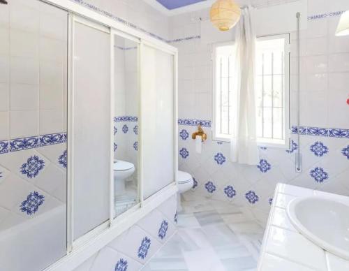 een blauwe en witte badkamer met een toilet en een wastafel bij Charming house in Arcos with private pool in Arcos de la Frontera