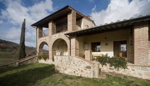 a large stone house on top of a field at Collepetrucci in Ciciano