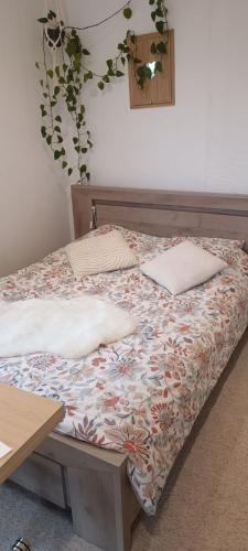 un lit avec des oreillers dessus dans une chambre dans l'établissement le petit cocon, à Montbozon