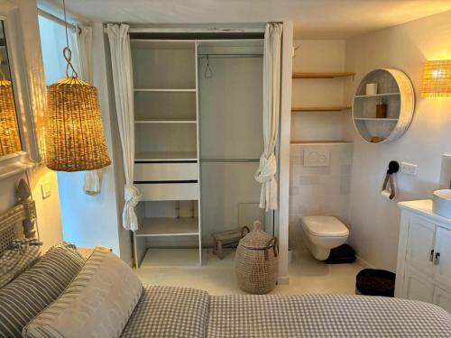 - une chambre avec un lit, des toilettes et un miroir dans l'établissement Jolie maison en pleine nature, à Tourrettes-sur-Loup