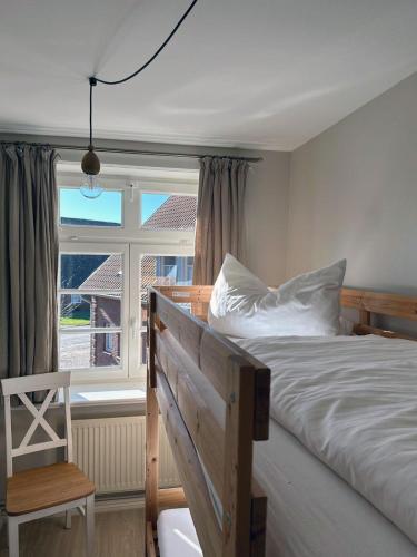 a bedroom with a bed and a window at Landhaus Osterrade in Bovenau