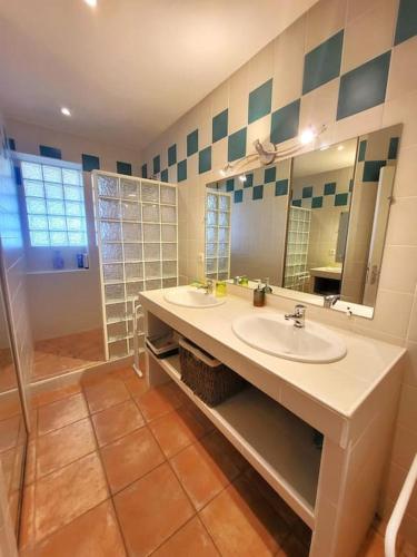 une salle de bain avec deux lavabos et une douche dans l'établissement Le repère de Saint Mathieu, à Plougonvelin