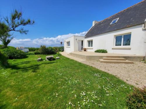 a white house with a grass yard next to a house at Le repère de Saint Mathieu in Plougonvelin
