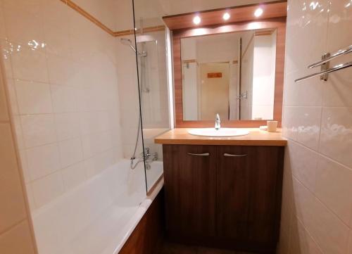 une salle de bain avec un lavabo, une douche et un miroir dans l'établissement Résidence Chaviere - Studio ski aux pieds au coeur des Ménuires MAE-4114, aux Menuires