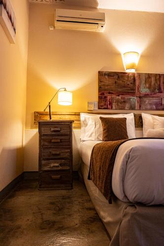 a bedroom with a bed and a dresser with a lamp at Posada Borravino in Chacras de Coria
