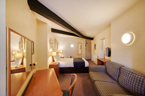 a hotel room with a bed and a couch at Discovery Inn - Leeds in Leeds