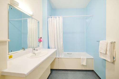 a bathroom with a sink and a mirror at Discovery Inn - Leeds in Leeds