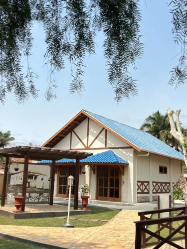 a house with a blue roof at Pousada Villa Da Montanha in São Bento do Sapucaí