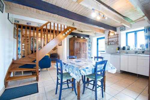 une cuisine et une salle à manger avec une table et un escalier dans l'établissement Le Gaoulac'H I Vue mer & Grand jardin, à Crozon