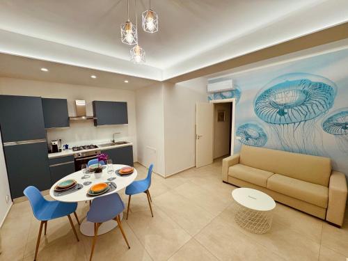 ein Wohnzimmer mit Tisch, Stühlen und Sofa in der Unterkunft MSApartments in Marina di Ragusa