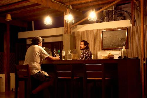 a man and a woman sitting at a bar at Casa Losodeli & Coworking- Adults Only in Puerto Escondido