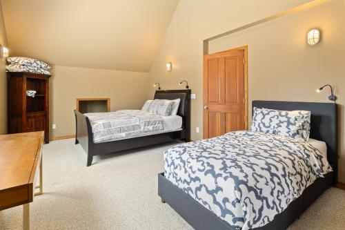 a bedroom with two beds and a table and a desk at Forest Escape in Cle Elum
