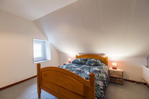 une chambre avec un lit en bois et une fenêtre dans l'établissement Les Choucas Maison familiale coeur de campagne, à Plouaret