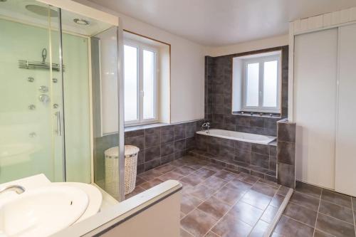 une salle de bain avec une baignoire, un lavabo et une douche dans l'établissement Les Choucas Maison familiale coeur de campagne, à Plouaret