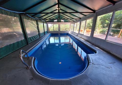 a large swimming pool with blue water in a building at Ruma Andina by DOT Cabana in Villa La Angostura