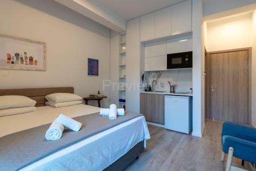 a bedroom with a bed and a kitchen in it at Le Voyageur By the Sea - Furnished Rooms in Larnaka