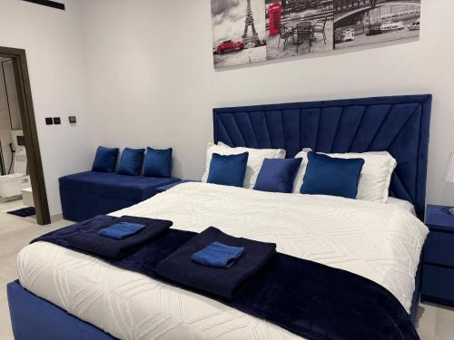 a bedroom with a blue bed with blue pillows at Jumeirah Heights in Dubai