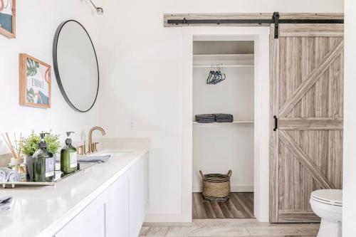 baño con aseo y puerta corredera de granero en 3BR Modern, Gated Home w FreePking, BBQ, Firepit, Mins to Downtown, en San Antonio