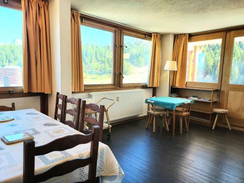 une pièce avec une table, des chaises et des fenêtres dans l'établissement Résidence L'everest - Résidence EVEREST N°74 MAE-4641, à La Plagne Tarentaise
