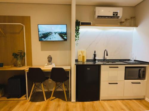 a kitchen with a table and chairs and a tv on the wall at Apê Brás - Shopping Plaza Polo in Sao Paulo