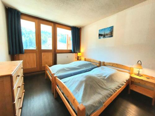 une chambre avec un lit, un bureau et des fenêtres dans l'établissement Résidence L'everest - Résidence EVEREST N°74 MAE-4641, à La Plagne Tarentaise