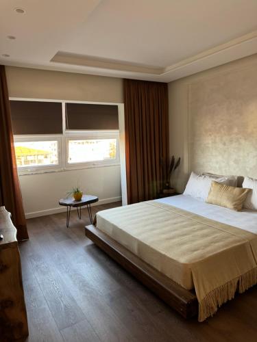 a bedroom with a large bed and a window at R&DLux in Durrës