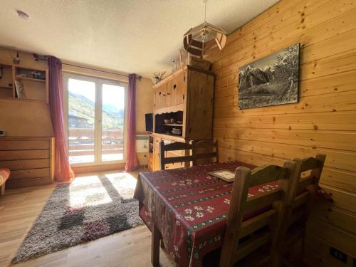 Cette chambre en bois dispose d'une table et d'une fenêtre. dans l'établissement Résidence Meije 10- Porte J3 - Coquet appartement au Village 1800 dans station LES 2 ALPES MAE-5411, à Vénosc