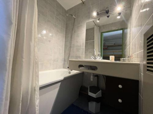 une salle de bain avec une baignoire, un lavabo et un miroir dans l'établissement Résidence Meije 10- Porte J3 - Coquet appartement au Village 1800 dans station LES 2 ALPES MAE-5411, à Vénosc