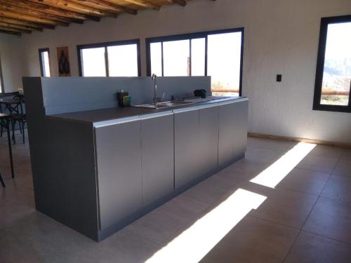 a kitchen with a sink in a room with windows at Casa del Plata Lodge in Potrerillos