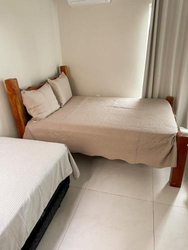 a bedroom with two beds and a window at Aconchego dos Netos 4 - TAIPU DE FORA in Taipu