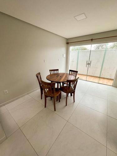 a dining room with a table and chairs and a large window at Aconchego dos Netos 4 - TAIPU DE FORA in Taipu