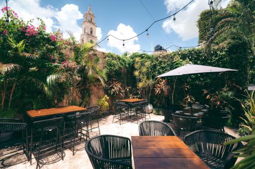 an outdoor restaurant with tables and chairs and flowers at Piedra de Agua Merida in Mérida