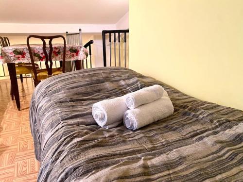 Dos toallas enrolladas encima de una cama en Casa Angela, en Militello in Val di Catania