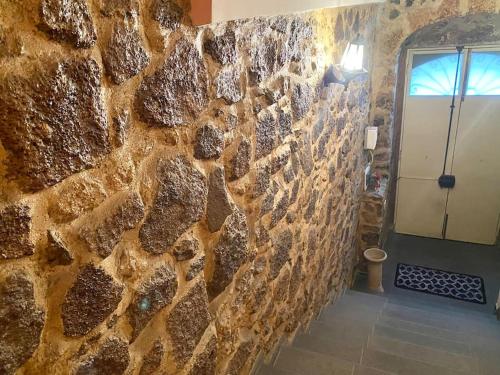 pared de piedra con puerta y puerta en Casa Angela, en Militello in Val di Catania