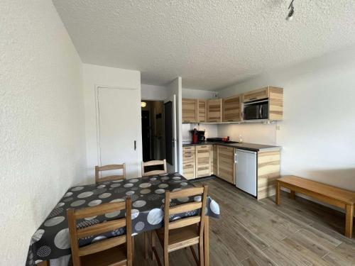 une petite cuisine avec une table et des chaises dans une pièce dans l'établissement Résidence Soldanelle - Agréable studio exposé sud au départ des pistes MAE-6601, à Vénosc
