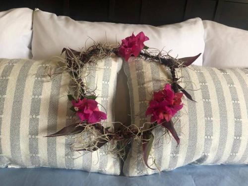 a wreath on a bed with red flowers on it at Central Oceanview Modern Cozy 3 Bed House in Kailua-Kona