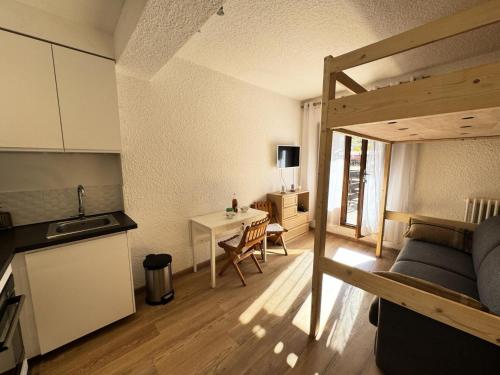 Ce petit appartement comprend un lit, un bureau et une cuisine. dans l'établissement Résidence Le Sporting - Studio · Chaleureux · Grande terrasse MAE-1451, à La Salle Les Alpes