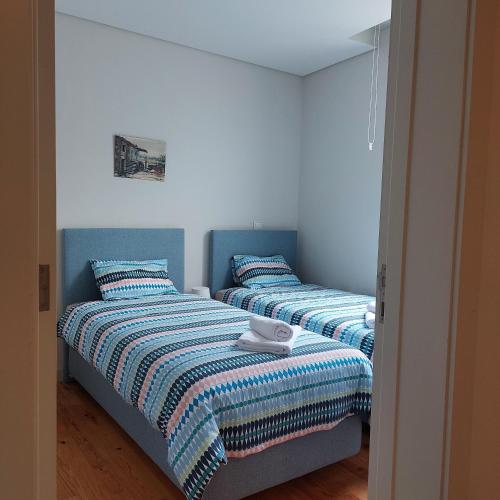 two beds sitting next to each other in a bedroom at SpinBay Apartment in Espinho