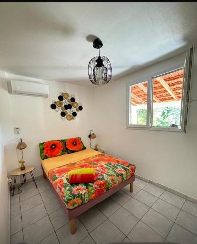 a bedroom with a bed and a window at Résidence Flores De Maria in Le Marin