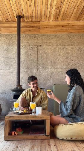a man and woman sitting at a table eating food at La Calma Ecolodge in Las Heras