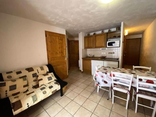 - une cuisine avec un canapé et une table dans une chambre dans l'établissement Chalets D Or - Charmant T2 avec terrasse et place de parking privée MAE-5611, à Vénosc
