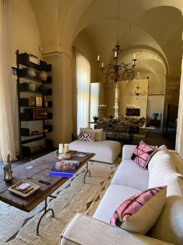a living room with two white couches and a table at Dimora Enricuzzo Modica in Modica